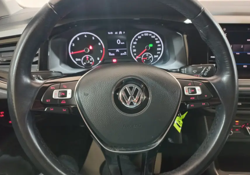 Vue rapprochée du volant en cuir noir d'une Volkswagen Polo 2020 avec tableau de bord numérique et commandes intégrées.