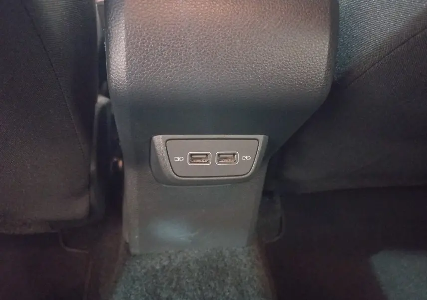 Prise double USB pour recharge située à l'arrière de la console centrale dans l'habitacle noir d'une Volkswagen Polo 2020.