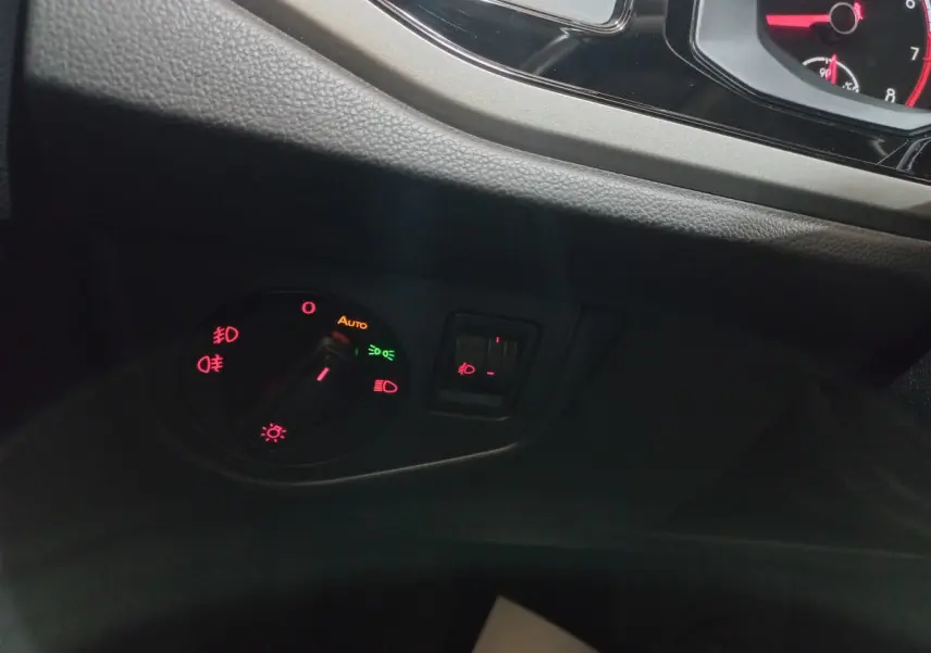 Gros plan sur le bouton de commande des phares et réglage des feux antibrouillard dans l'habitacle d'une Volkswagen Polo noire 2020.