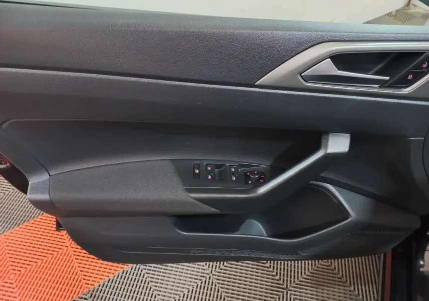 Vue rapprochée de la porte côté gauche noire de la Volkswagen Polo 2020 avec commandes électriques des vitres et serrure intégrée.