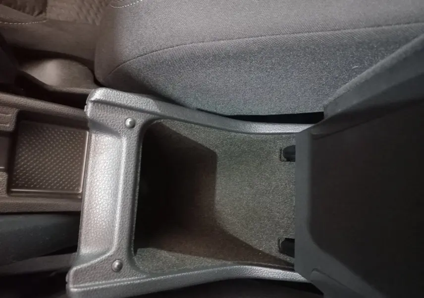 Vue rapprochée de la console centrale noire ouverte entre les sièges avant d'une Volkswagen Polo 2020.