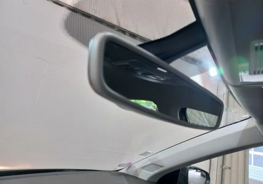 Vue intérieure du rétroviseur central d'une Volkswagen Polo noire 2020, avec partie du pare-brise et montant de porte visible.