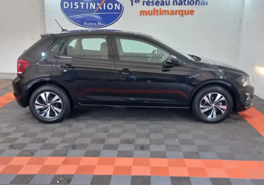 Profil côté gauche d'une Volkswagen Polo noire 2020 dans un showroom avec jantes alliage et vitres teintées.
