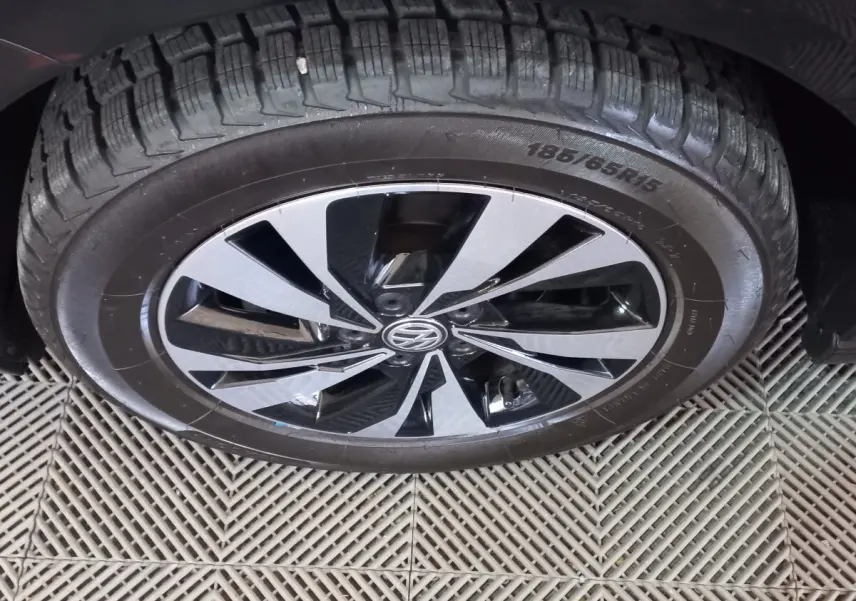 Gros plan sur la roue avant droite d'une Volkswagen Polo noire avec jante alliage bicolore moderne.