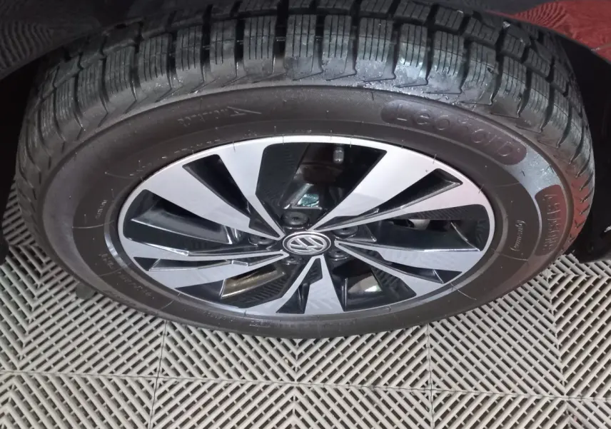 Gros plan sur la roue avant droite noire d'une Volkswagen Polo 1.0 TSI 95 DSG7 Lounge Business avec jante alliage bicolore.