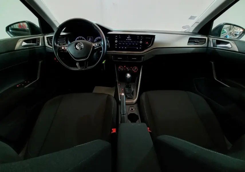 Vue intérieure frontale de la Volkswagen Polo noire 2020, tableau de bord avec écran tactile et volant multifonctions.