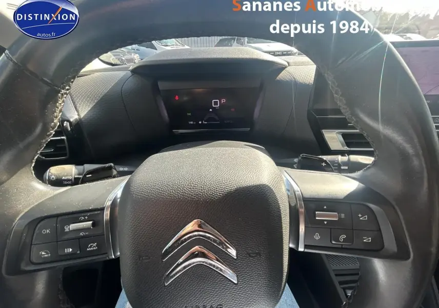 Vue rapprochée du volant cuir noir de la Citroën C4 2021 avec commandes intégrées et tableau de bord digital.