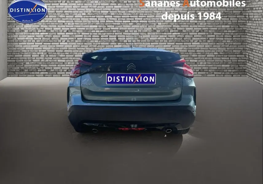 Vue arrière d'une Citroën C4 bleu clair 2021 avec feux distinctifs et double sortie d'échappement dans un garage.