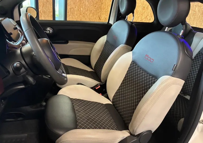Vue intérieure côté gauche de la Fiat 500 2021, sièges bicolores noir et crème avec logo 500 brodé rouge.