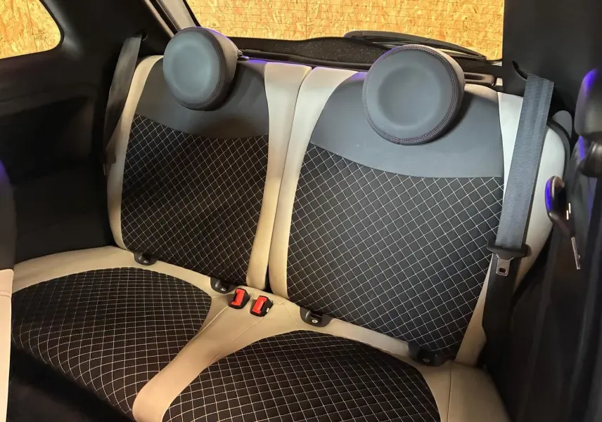 Vue rapprochée des sièges arrière en tissu noir à motifs blancs avec contours crème d'une Fiat 500 DolceVita 2021.