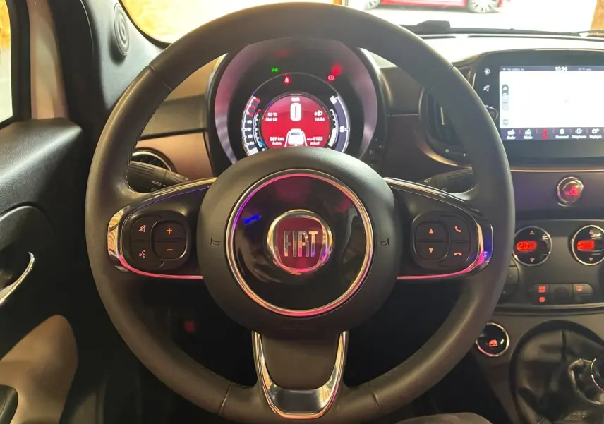 Vue centrée sur le volant noir de la Fiat 500 2021 avec tableau de bord numérique et écran tactile visible.