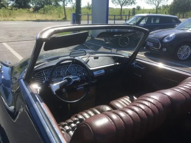 Intérieur du cabriolet Citroën DS3 DS21 Chapron 1967 bleu marine, vue côté conducteur avec tableau de bord vintage et sièges en cuir marron.