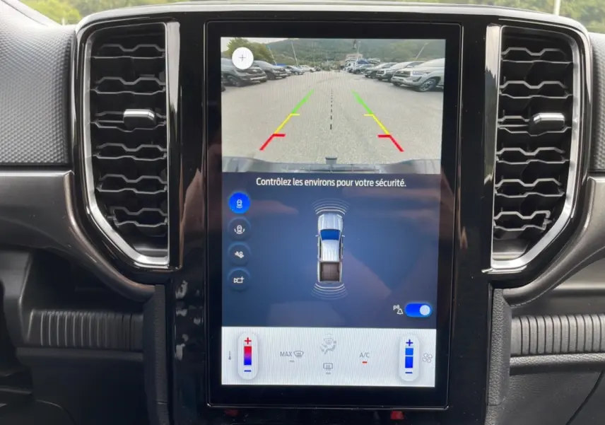 Écran central du Ford Ranger 2025 montrant la caméra de recul avec guidage coloré dans un intérieur noir.