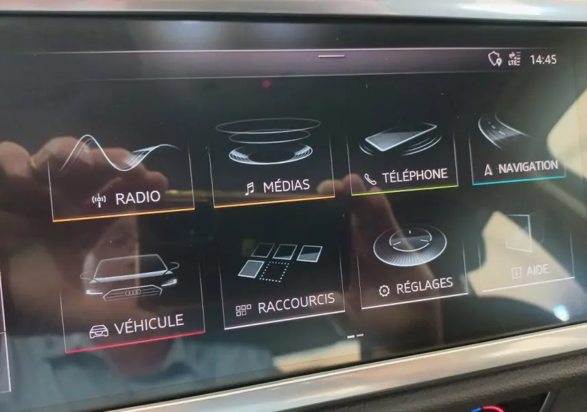 Écran tactile central de l'Audi Q3 Sportback 35 TDI noir, affichant les menus radio, médias, téléphone et navigation.