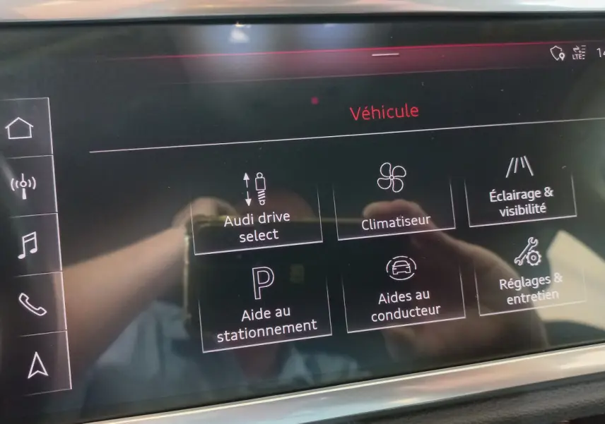 Écran tactile central de l'Audi Q3 Sportback 35 TDI noir, affichant les options de véhicule et aides à la conduite.