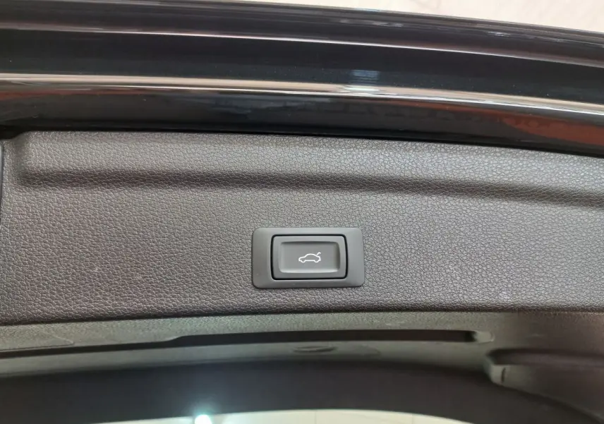 Bouton d'ouverture électrique du coffre sur la partie intérieure du hayon noir de l'Audi Q3 Sportback 2020.