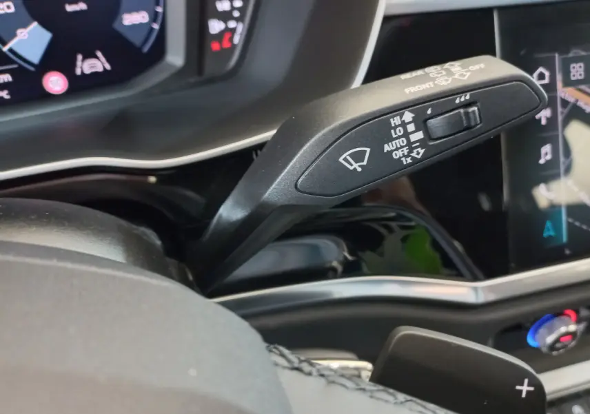 Gros plan sur la manette de commande des essuie-glaces dans l'habitacle noir de l'Audi Q3 Sportback 2020.