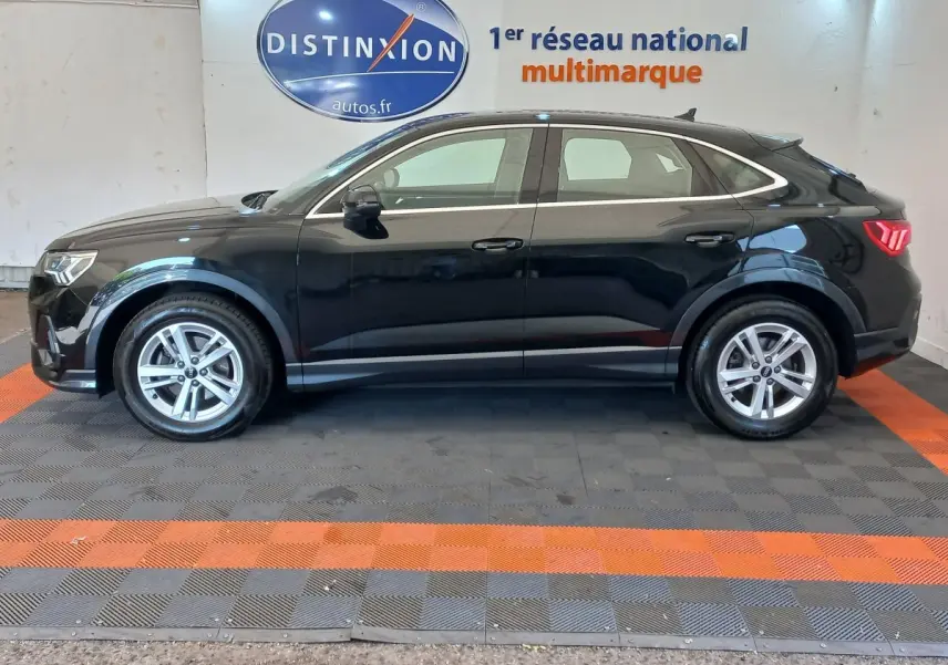 Profil côté gauche d'un Audi Q3 Sportback noir 2020, soulignant ses lignes fluides et ses feux arrière LED distinctifs.
