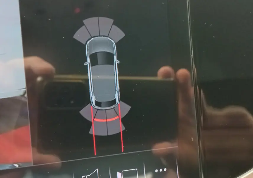 Affichage tactile montrant la vue de dessus du Audi Q3 Sportback noir avec guidage de trajectoire au stationnement arrière.