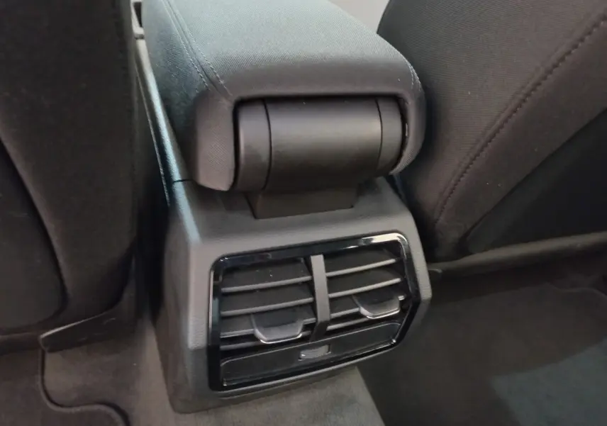Détail des aérateurs arrière noirs et accoudoir central entre les sièges arrière d'un Audi Q3 Sportback noir.
