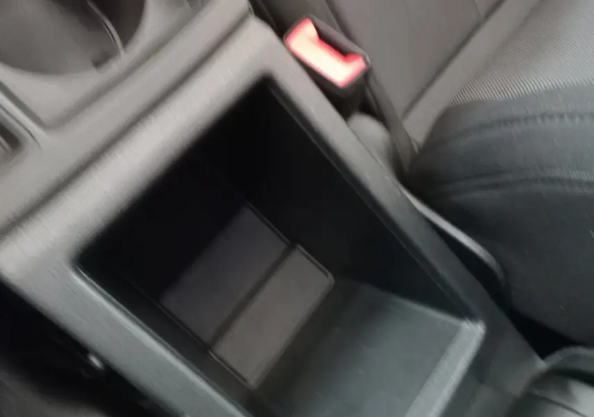 Gros plan sur le rangement central noir entre les sièges avant d'un Audi Q3 Sportback 35 TDI 2020.