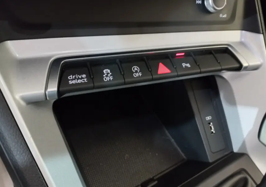 Gros plan sur la console centrale de l'Audi Q3 Sportback 35 TDI, boutons de contrôle et port USB visibles.