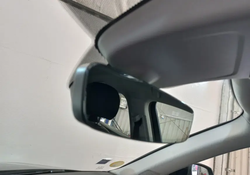 Rétroviseur intérieur de l'Audi Q3 Sportback noir 2020, avec vue partielle sur l'appui-tête et la portière côté gauche.