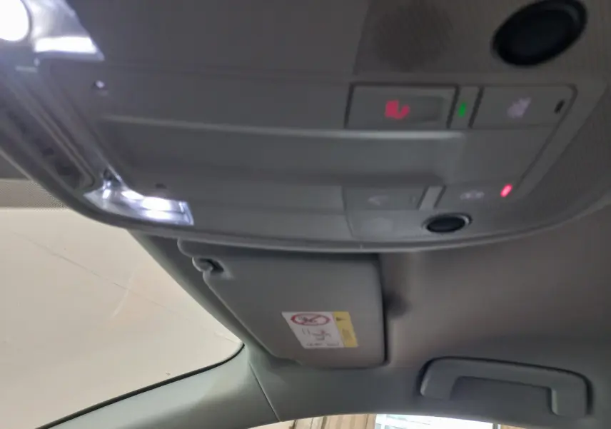 Vue intérieure du plafond avant de l'Audi Q3 Sportback noir 2020, avec commandes d'éclairage et pare-soleil côté conducteur.