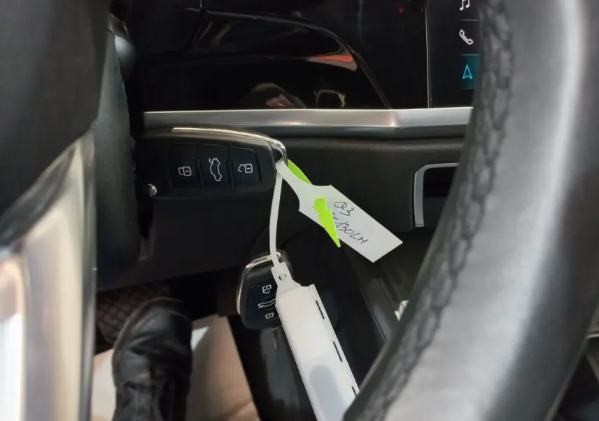 Gros plan sur la clé noire de l'Audi Q3 Sportback 35 TDI avec étiquette, près du tableau de bord et volant cuir.