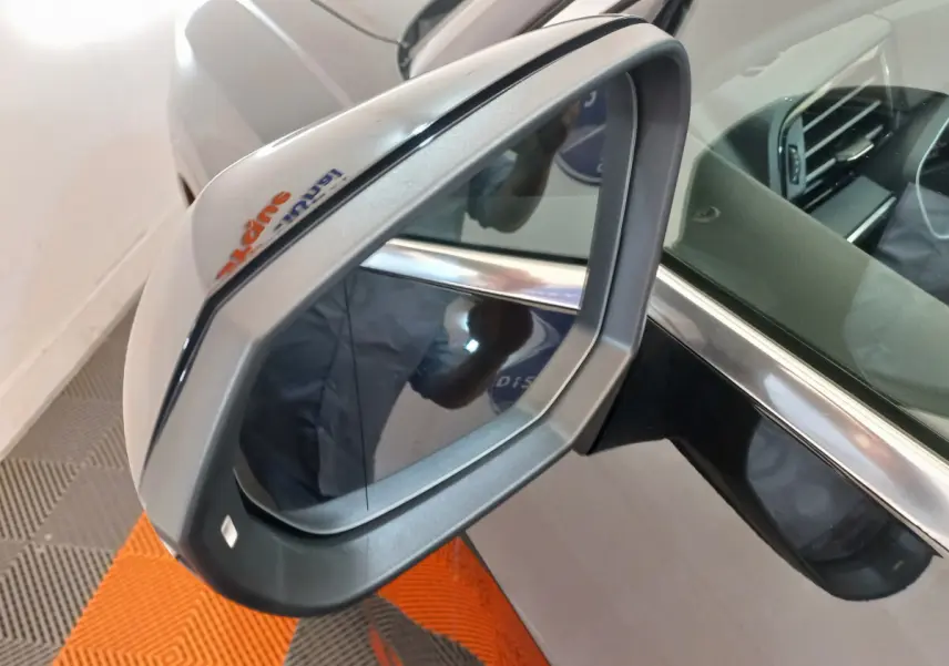 Rétroviseur droit gris métallisé de l'Audi Q3 Sportback noir, avec reflet intérieur et cadre chromé visible.