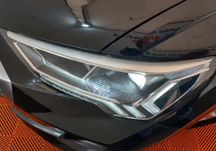 Gros plan sur le phare avant droit du SUV Audi Q3 Sportback noir, mettant en valeur son design LED distinctif.