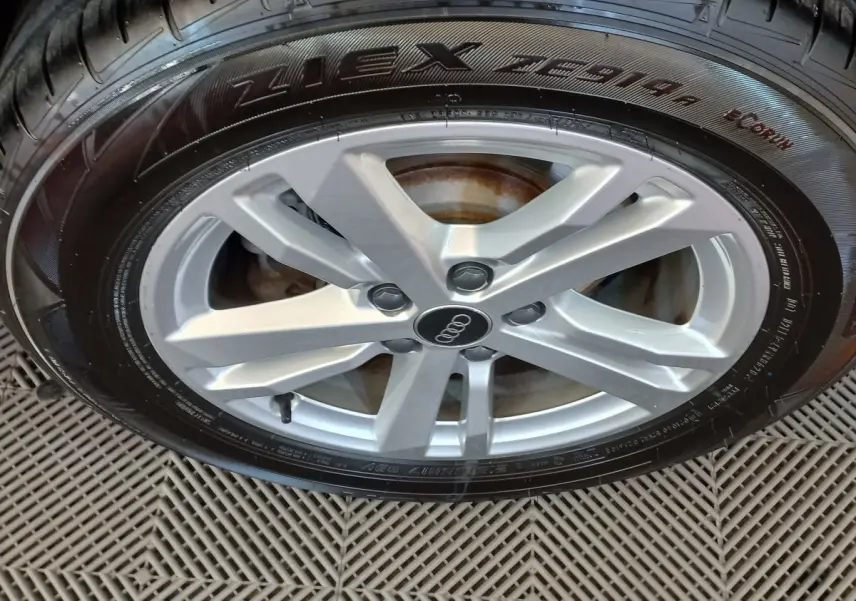 Gros plan sur la jante argentée avec logo Audi d’un Audi Q3 Sportback noir, mettant en valeur le pneu Nexen.