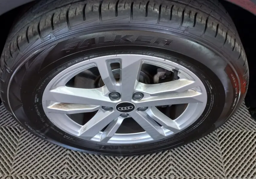 Gros plan sur la jante argentée et le pneu Falken d’un Audi Q3 Sportback noir, vue latérale rapprochée.