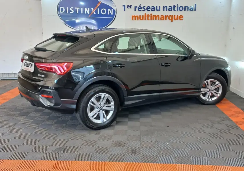 Audi Q3 Sportback noir vue de profil côté droit, soulignant ses lignes fluides et ses feux arrière LED distinctifs.