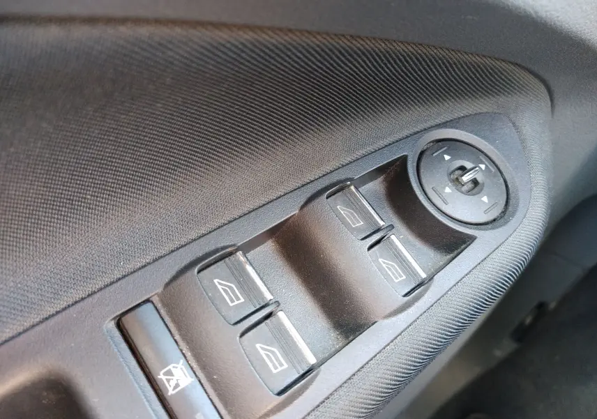 Gros plan sur les commandes de lève-vitres et réglage des rétroviseurs sur la porte côté conducteur d'une Ford C-MAX 2013.