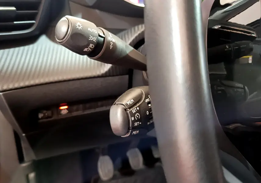 Gros plan sur les commandes au volant cuir noir du Peugeot 2008 PureTech 130 S&S Allure Business 2021.