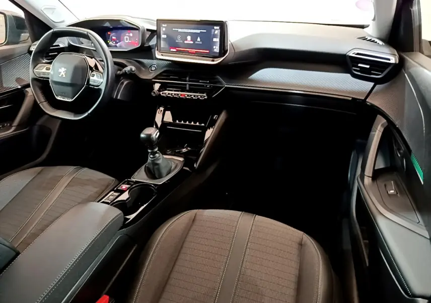 Intérieur noir de la Peugeot 2008 PureTech 130, vue de face montrant volant cuir, écran tactile et levier de vitesse manuel.