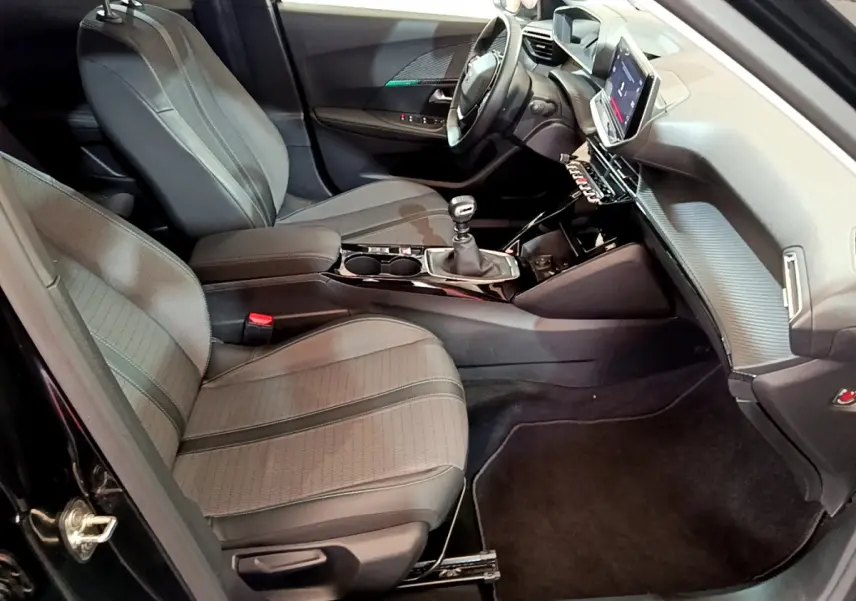 Intérieur de la Peugeot 2008 noir, vue côté conducteur, avec tableau de bord moderne et écran tactile central.