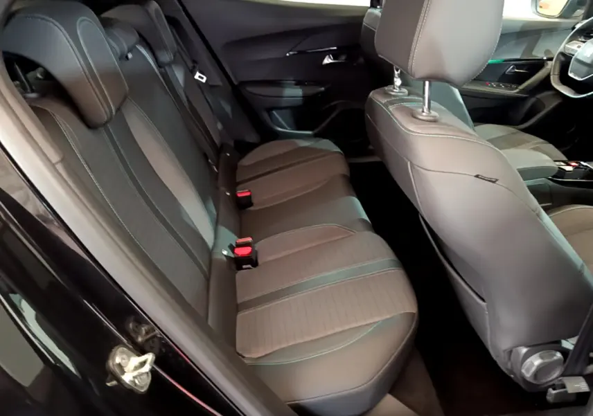 Vue intérieure côté gauche sur la banquette arrière et sièges avant en tissu gris du Peugeot 2008 noir 2021 PureTech 130 Allure Business
