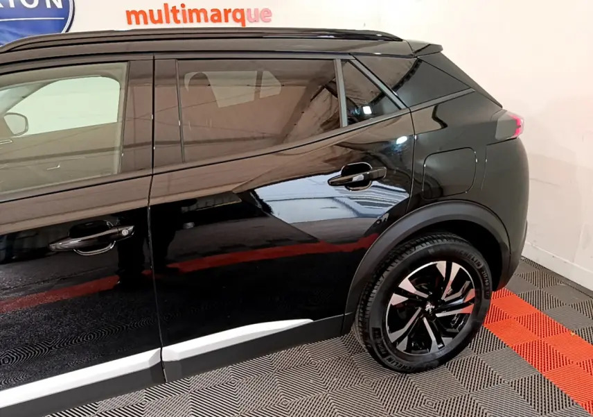 Profil côté droit du Peugeot 2008 noir 2021 avec jantes alliage et poignées de porte assorties.