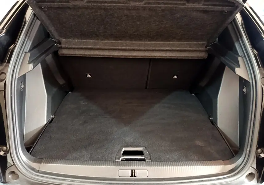 Coffre ouvert vu de l'arrière d'un Peugeot 2008 noir, montrant un espace de chargement propre et spacieux.