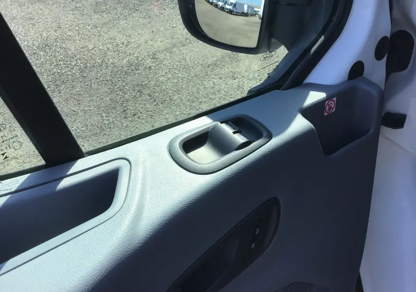 Vue rapprochée de la portière côté gauche du Ford Transit Châssis Cabine blanc, montrant la poignée et le rétroviseur électrique.