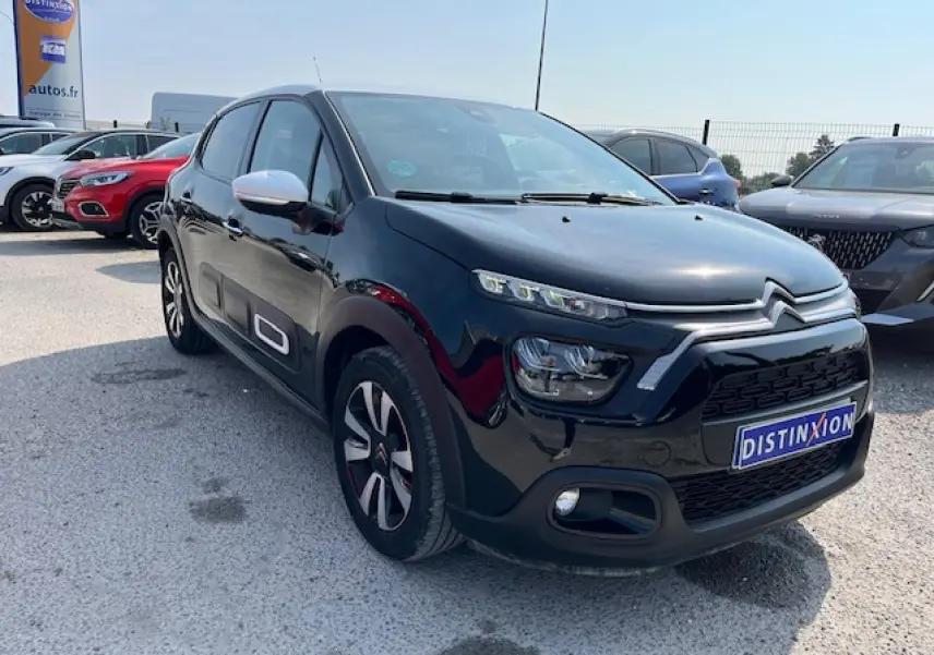 Citroën C3 noire vue en 3/4 avant droit, avec jantes alliage et rétroviseurs blancs contrastants.