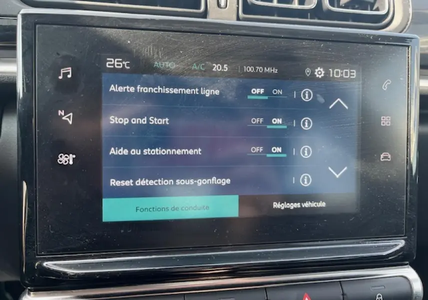 Gros plan sur l'écran tactile central de la Citroën C3 noire 2023 montrant les réglages d'aide à la conduite.