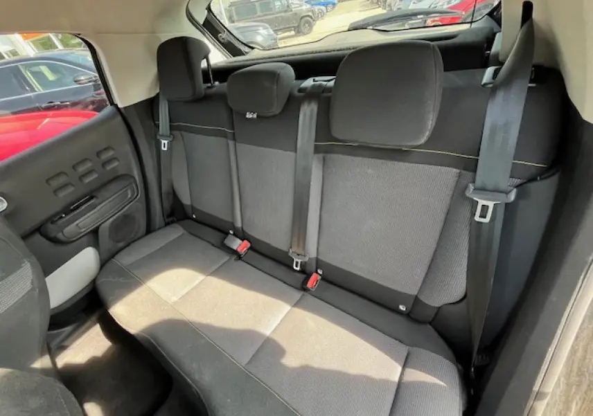 Banquette arrière noire et grise de la Citroën C3 2023, vue de côté droit avec ceintures et appuie-têtes visibles.