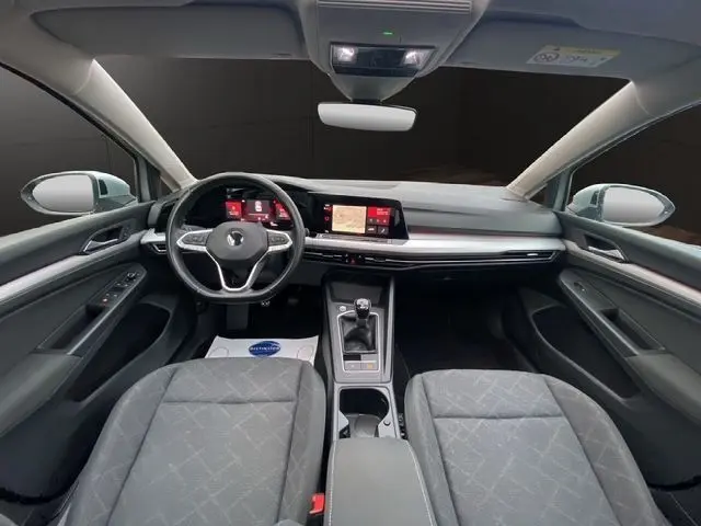 Intérieur noir de la Volkswagen Golf VIII 2.0 TDI 115 Life, vue frontale du tableau de bord avec écran tactile et boîte manuelle.