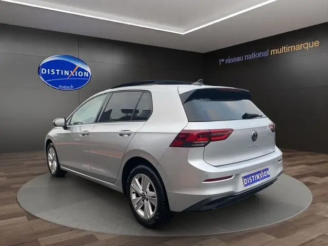 Volkswagen Golf VIII gris argent vue 3/4 arrière gauche avec toit panoramique ouvrant et vitres surteintées.