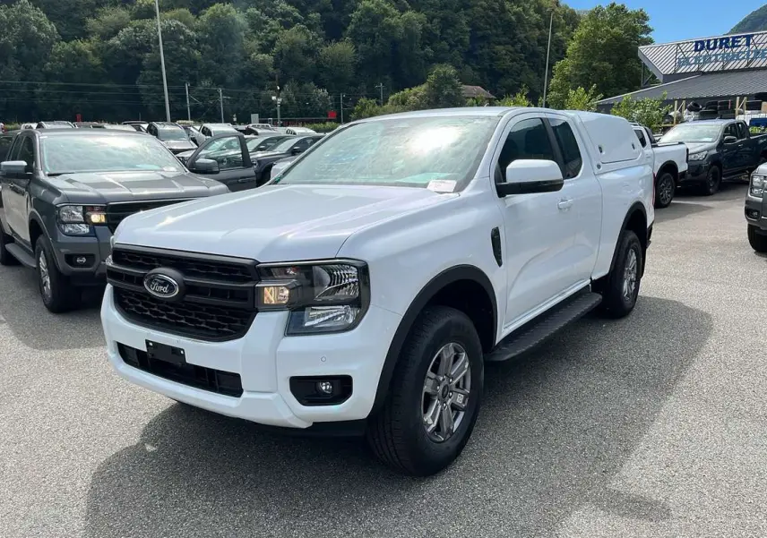 Ford Ranger blanc glacier 2025 en 3/4 avant droit avec hard-top sur la benne et jantes alliage.