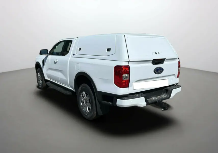 Ford Ranger blanc glacier en vue 3/4 arrière droit avec benne couverte et attelage visible