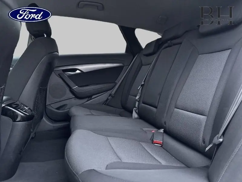 Vue intérieure arrière montrant les sièges en tissu gris foncé d'une Hyundai i40 SW 2017.